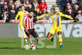2022-02-12 - Bryan Mbeumo (19) of Brentford tussles with Wilfried Zaha (11) of Crystal Palace during the English championship Premier League football match between Brentford and Crystal Palace on February 12, 2022 at Brentford Community Stadium in Brentford, England - BRENTFORD VS CRYSTAL PALACE - ENGLISH PREMIER LEAGUE - SOCCER