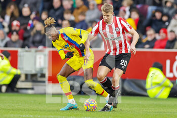 2022-02-12 - Kristoffer Ajer (20) of Brentford tussles with Wilfried Zaha (11) of Crystal Palace during the English championship Premier League football match between Brentford and Crystal Palace on February 12, 2022 at Brentford Community Stadium in Brentford, England - BRENTFORD VS CRYSTAL PALACE - ENGLISH PREMIER LEAGUE - SOCCER