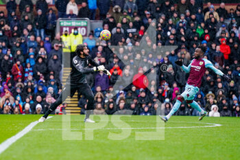 2022-02-13 - Liverpool goalkeeper Alisson Becker (1) headers the ball away from Burnley forward Maxwel Cornet during the English championship Premier League football match between Burnley and Liverpool on February 13, 2022 at Turf Moor in Burnley, England - BURNLEY VS LIVERPOOL - ENGLISH PREMIER LEAGUE - SOCCER