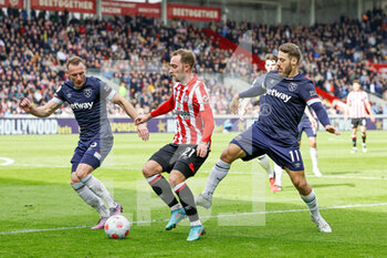 2022-04-10 - Christian Eriksen (21) of Brentford tussles with Nikola Vlasic (11) of West Ham during the English championship Premier League football match between Brentford and West Ham United on April 10, 2022 at Brentford Community Stadium in Brentford, England - BRENTFORD VS WEST HAM UNITED - ENGLISH PREMIER LEAGUE - SOCCER