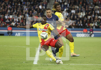 2022-04-23 - Kylian Mbappe of PSG between Deiver Machado and Christopher Wooh of Lens during the French championship Ligue 1 football match between Paris Saint-Germain (PSG) and RC Lens (RCL) on April 23, 2022 at Parc des Princes stadium in Paris, France - PARIS SAINT-GERMAIN VS RC LENS - FRENCH LIGUE 1 - SOCCER