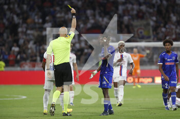 2022-08-19 - Referee Eric WATTELLIER yellow card N’Guessan KOUAME of Troyes during the French championship Ligue 1 football match between Olympique Lyonnais (Lyon) and ESTAC Troyes on August 19, 2022 at Groupama stadium in Decines-Charpieu near Lyon, France - FOOTBALL - FRENCH CHAMP - LYON V TROYES - FRENCH LIGUE 1 - SOCCER