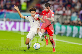 21/11/2022 - Tyler Adams (4) of United States slides in and tackles Neco Williams (3) of Wales during the FIFA World Cup 2022, Group B football match between United States and Wales on November 21, 2022 at Ahmad Bin Ali Stadium in Ar-Rayyan, Qatar - FOOTBALL - WORLD CUP 2022 - UNITED STATES V WALES - FIFA MONDIALI - CALCIO