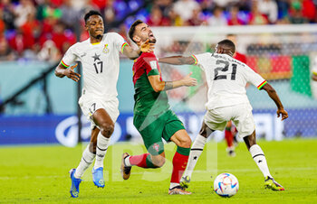2022-11-24 - Bruno Fernandes (8) of Portugal gets sandwiched between Salis Abdul Samed (21) of Ghana and Baba Rahman (17) of Ghana during the Fifa World Cup 2022, Group H football match between Portugal and Ghana on November 24, 2022 at Stadium 974 in Doha, Qatar - FOOTBALL - WORLD CUP 2022 - PORTUGAL V GHANA - FIFA WORLD CUP - SOCCER