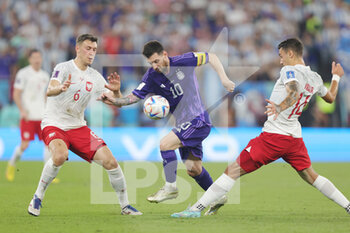 2022-11-30 - Lionel Messi of Argentina and Krystian Bielik, Jakub Kiwior of Poland during the FIFA World Cup 2022, Group C football match between Poland and Argentina on November 30, 2022 at Stadium 974 in Doha, Qatar - FOOTBALL - WORLD CUP 2022 - POLAND V ARGENTINA - FIFA WORLD CUP - SOCCER
