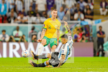 2022-12-04 - Cristian Romero (13) of Argentina slides in and tackles Mitchell Duke (15) of Australia during the FIFA World Cup 2022, Round of 16 football match between Argentina and Australia on December 3, 2022 at Ahmad Bin Ali Stadium in Al Rayyan, Qatar - FOOTBALL - WORLD CUP 2022 - 1/8 - ARGENTINA V AUSTRALIA - FIFA WORLD CUP - SOCCER