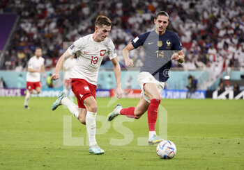 2022-12-04 - Adrien Rabiot of France, Jakub Kaminski of Poland (left) during the FIFA World Cup 2022, Round of 16 football match between France and Poland on December 4, 2022 at Al Thumama Stadium in Doha, Qatar - FOOTBALL - WORLD CUP 2022 - 1/8 - FRANCE V POLAND - FIFA WORLD CUP - SOCCER