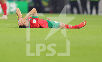 2022-12-10 - Romain Saiss of Morocco injured during the FIFA World Cup 2022, Quarter-final football match between Morocco and Portugal on December 10, 2022 at Al Thumama Stadium in Doha, Qatar - FOOTBALL - WORLD CUP 2022 - 1/4 - MOROCCO V PORTUGAL - FIFA WORLD CUP - SOCCER