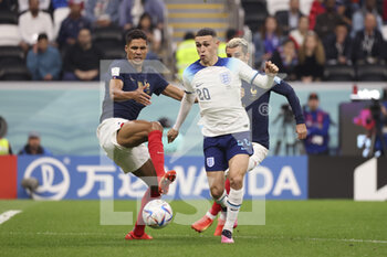 2022-12-10 - Phil Foden of England, Raphael Varane of France (left) during the FIFA World Cup 2022, Quarter-final football match between England and France on December 10, 2022 at Al Bayt Stadium in Al Khor, Qatar - FOOTBALL - WORLD CUP 2022 - 1/4 - ENGLAND V FRANCE - FIFA WORLD CUP - SOCCER