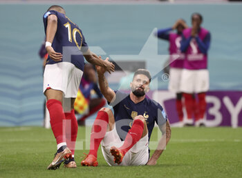 2022-12-10 - Olivier Giroud of France is helped by Kylian Mbappe of France (left) during the FIFA World Cup 2022, Quarter-final football match between England and France on December 10, 2022 at Al Bayt Stadium in Al Khor, Qatar - FOOTBALL - WORLD CUP 2022 - 1/4 - ENGLAND V FRANCE - FIFA WORLD CUP - SOCCER