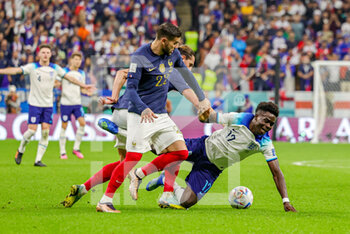 2022-12-11 - Bukayo Saka (17) of England and Theo Hernandez, Adrien Rabiot of France during the FIFA World Cup 2022, Quarter-final football match between England and France on December 10, 2022 at Al Bayt Stadium in Al Khor, Qatar - FOOTBALL - WORLD CUP 2022 - 1/4 - ENGLAND V FRANCE - FIFA WORLD CUP - SOCCER