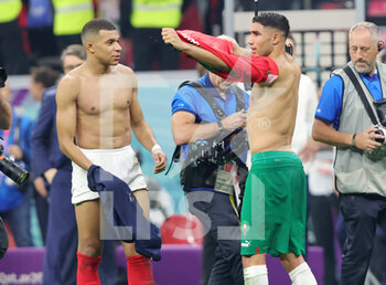 2022-12-14 - Paris Saint-Germain teammates Kylian Mbappe of France and Achraf Hakimi of Morocco at full time during the FIFA World Cup 2022, Semi-final football match between France and Morocco on December 14, 2022 at Al Bayt Stadium in Al Khor, Qatar - FOOTBALL - WORLD CUP 2022 - 1/2 - FRANCE V MOROCCO - FIFA WORLD CUP - SOCCER