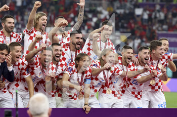 2022-12-17 - Luka Modric of Croatia and teammates celebrate during the 3rd place medal ceremony following the FIFA World Cup 2022, third place football match between Croatia and Morocco on December 17, 2022 at Khalifa International Stadium in Ar-Rayyan, Qatar - FOOTBALL - WORLD CUP 2022 - 3RD PLACE - CROATIA V MOROCCO - FIFA WORLD CUP - SOCCER