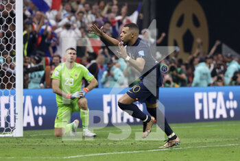 2022-12-18 - Kylian Mbappe of France celebrates his third goal while Argentina goalkeeper Emiliano Martinez aka Damian Martinez looks on during the FIFA World Cup 2022, Final football match between Argentina and France on December 18, 2022 at Lusail Stadium in Al Daayen, Qatar - FOOTBALL - WORLD CUP 2022 - FINAL - ARGENTINA V FRANCE - FIFA WORLD CUP - SOCCER
