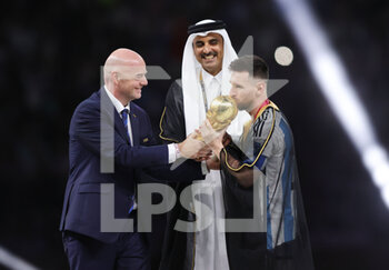 2022-12-18 - Lionel Messi of Argentina celebrates with the trophy with FIFA President Giovanni Infantino, cheikh Tamim ben Hamad Al Thani after the FIFA World Cup 2022, Final football match between Argentina and France on December 18, 2022 at Lusail Stadium in Al Daayen, Qatar - FOOTBALL - WORLD CUP 2022 - FINAL - ARGENTINA V FRANCE - FIFA WORLD CUP - SOCCER