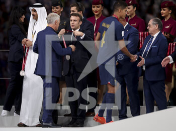 2022-12-18 - Emir of Qatar Sheikh Tamim bin Hamad Al Thani, President of France Emmanuel Macron, FFF President Noel Le Graet give the medals to coach of France Didier Deschamps, Raphael Varane during the trophy ceremony following the FIFA World Cup 2022, Final football match between Argentina and France on December 18, 2022 at Lusail Stadium in Al Daayen, Qatar - FOOTBALL - WORLD CUP 2022 - FINAL - ARGENTINA V FRANCE - FIFA WORLD CUP - SOCCER