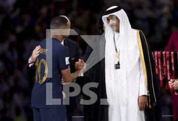 2022-12-18 - Kylian Mbappe of France, Emir of Qatar Sheikh Tamim bin Hamad Al Thani during the trophy ceremony following the FIFA World Cup 2022, Final football match between Argentina and France on December 18, 2022 at Lusail Stadium in Al Daayen, Qatar - FOOTBALL - WORLD CUP 2022 - FINAL - ARGENTINA V FRANCE - FIFA WORLD CUP - SOCCER