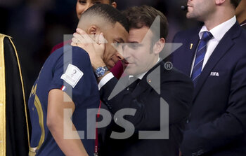 2022-12-18 - Kylian Mbappe of France is consoled by President of France Emmanuel Macron during the trophy ceremony following the FIFA World Cup 2022, Final football match between Argentina and France on December 18, 2022 at Lusail Stadium in Al Daayen, Qatar - FOOTBALL - WORLD CUP 2022 - FINAL - ARGENTINA V FRANCE - FIFA WORLD CUP - SOCCER