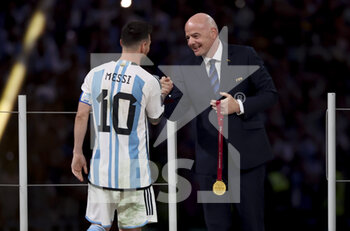 2022-12-18 - Lionel Messi of Argentina, FIFA President Gianni Infantino during the trophy ceremony following the FIFA World Cup 2022, Final football match between Argentina and France on December 18, 2022 at Lusail Stadium in Al Daayen, Qatar - FOOTBALL - WORLD CUP 2022 - FINAL - ARGENTINA V FRANCE - FIFA WORLD CUP - SOCCER
