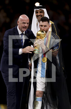 2022-12-18 - FIFA President Gianni Infantino, Emir of Qatar Sheikh Tamim bin Hamad Al Thani, Lionel Messi of Argentina kissing the World Cup during the trophy ceremony following the FIFA World Cup 2022, Final football match between Argentina and France on December 18, 2022 at Lusail Stadium in Al Daayen, Qatar - FOOTBALL - WORLD CUP 2022 - FINAL - ARGENTINA V FRANCE - FIFA WORLD CUP - SOCCER