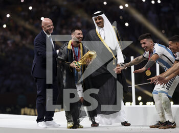 2022-12-18 - FIFA President Gianni Infantino, Emir of Qatar Sheikh Tamim bin Hamad Al Thani and Lionel Messi of Argentina holding the World Cup during the trophy ceremony following the FIFA World Cup 2022, Final football match between Argentina and France on December 18, 2022 at Lusail Stadium in Al Daayen, Qatar - FOOTBALL - WORLD CUP 2022 - FINAL - ARGENTINA V FRANCE - FIFA WORLD CUP - SOCCER