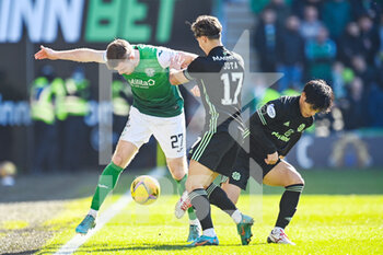 2022-02-27 - Hibs? Chris Cadden is tackled by Celtic's Jota and Celtic's Rey Hatate during the Scottish championship, Cinch Premiership football match between Hibernian and Celtic on February 27, 2022 at Easter Road Stadium in Edinburgh, Scotland - HIBERNIAN VSCELTIC - SCOTTISH PREMIERSHIP - SOCCER