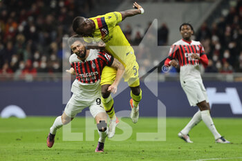 2022-04-04 - Olivier Giroud of AC Milan competes for the ball with Adama Soumaoro of Bologna FC during the Serie A 2021/22 football match between AC Milan and Bologna FC at Giuseppe Meazza Stadium, Milan, Italy on April 04, 2022 - AC MILAN VS BOLOGNA FC - ITALIAN SERIE A - SOCCER