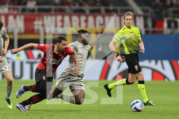 2022-04-15 - Caleb Ekuban of Genoa CFC competes for the ball with Ismael Bennacer of AC Milan during the Serie A 2021/22 football match between AC Milan and Genoa CFC at Giuseppe Meazza Stadium, Milan, Italy on April 15, 2022 - AC MILAN VS GENOA CFC - ITALIAN SERIE A - SOCCER