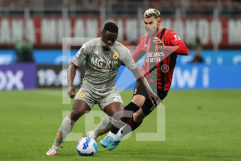 2022-04-15 - Caleb Ekuban of Genoa CFC competes for the ball with Theo Hernandez of AC Milan during the Serie A 2021/22 football match between AC Milan and Genoa CFC at Giuseppe Meazza Stadium, Milan, Italy on April 15, 2022 - AC MILAN VS GENOA CFC - ITALIAN SERIE A - SOCCER