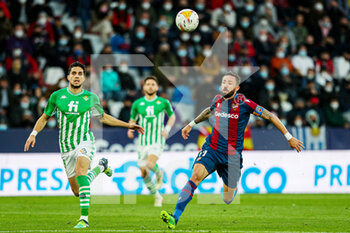 2022-02-13 - Jose Luis Morales of Levante UD and Marc Bartra of Real Betis during the Spanish championship La Liga football match between Levante UD and Real Betis Balompie on February 13, 2022 at the Ciutat de Valencia Stadium in Valencia, Spain - LEVANTE UD VS REAL BETIS BALOMPIE - SPANISH LA LIGA - SOCCER