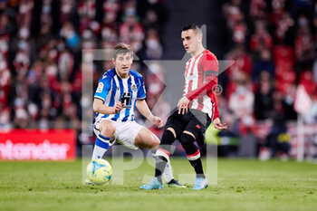 2022-02-20 - Alex Berenguer of Athletic Club competes for the ball with Aihen Munoz of Real Sociedad during the Spanish championship La Liga football match between Athletic Club and Real Sociedad on February 20, 2022 at San Mames stadium in Bilbao, Spain - ATHLETIC CLUB VS REAL SOCIEDAD - SPANISH LA LIGA - SOCCER