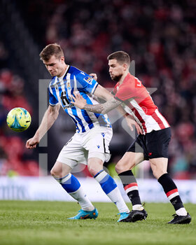 2022-02-20 - Alexander Sorloth of Real Sociedad competes for the ball with Inigo Martinez of Athletic Club during the Spanish championship La Liga football match between Athletic Club and Real Sociedad on February 20, 2022 at San Mames stadium in Bilbao, Spain - ATHLETIC CLUB VS REAL SOCIEDAD - SPANISH LA LIGA - SOCCER