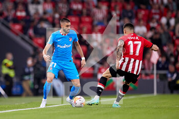 2022-04-30 - Yannick Carrasco of Atletico de Madrid competes for the ball with Iker Muniain of Athletic Club during the Spanish championship La Liga football match between Athletic Club and Atletico de Madrid on April 30, 2022 at San Mames stadium in Bilbao, Spain - ATHLETIC CLUB VS ATLETICO DE MADRID - SPANISH LA LIGA - SOCCER