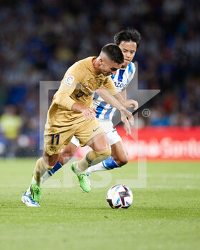 2022-08-21 - Ferran Torres of FC Barcelona competes for the ball with Takefusa Kubo of Real Sociedad during the Spanish championship La Liga football match between Real Sociedad and FC Barcelona on August 21, 2022 at Reale Arena in San Sebastian, Spain - FOOTBALL - SPANISH CHAMP - REAL SOCIEDAD V FC BARCELONA - SPANISH LA LIGA - SOCCER