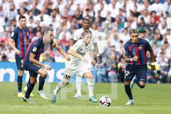 2022-10-16 - Luka Modric of Real Madrid and Sergio Busquet, Raphinha of FC Barcelona during the Spanish championship La Liga football match between Real Madrid and FC Barcelona on October 16, 2022 at Santiago Bernabeu stadium in Madrid, Spain - FOOTBALL - SPANISH CHAMP - REAL MADRID V FC BARCELONA - SPANISH LA LIGA - SOCCER