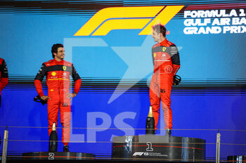 2022-03-20 - LECLERC Charles (mco), Scuderia Ferrari F1-75, portrait celebrating victory on the podium with SAINZ Carlos (spa), Scuderia Ferrari F1-75, portraitduring the Formula 1 Gulf Air Bahrain Grand Prix 2022, 1st round of the 2022 FIA Formula One World Championship, on the Bahrain International Circuit, from March 18 to 20, 2022 in Sakhir, Bahrain - FORMULA 1 GULF AIR BAHRAIN GRAND PRIX 2022, 1ST ROUND OF THE 2022 FIA FORMULA ONE WORLD CHAMPIONSHIP - FORMULA 1 - MOTORS
