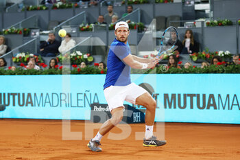 2022-05-04 - Lucas Pouille of France in action against Stefanos Tsitsipas of Greece during the Mutua Madrid Open 2022 tennis tournament on May 4, 2022 at Caja Magica stadium in Madrid, Spain - MUTUA MADRID OPEN 2022 TENNIS TOURNAMENT - INTERNATIONALS - TENNIS