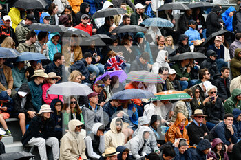 2022-05-25 - General view (illustration, atmosphere with the crowd (audience, public, spectators) of the court 14 brings out the umbrellas because of the rain during the French Open, Grand Slam tennis tournament on May 24, 2022 at Roland-Garros stadium in Paris, France - ROLAND-GARROS 2022, FRENCH OPEN 2022, GRAND SLAM TENNIS TOURNAMENT - INTERNATIONALS - TENNIS