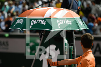 2022-05-25 - Illustration picture shows the umbrella or parasol held by a ball kid over a player because of the heat during the French Open, Grand Slam tennis tournament on May 24, 2022 at Roland-Garros stadium in Paris, France - ROLAND-GARROS 2022, FRENCH OPEN 2022, GRAND SLAM TENNIS TOURNAMENT - INTERNATIONALS - TENNIS