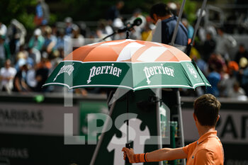 2022-05-25 - Illustration picture shows the umbrella or parasol held by a ball kid over a player because of the heat during the French Open, Grand Slam tennis tournament on May 24, 2022 at Roland-Garros stadium in Paris, France - ROLAND-GARROS 2022, FRENCH OPEN 2022, GRAND SLAM TENNIS TOURNAMENT - INTERNATIONALS - TENNIS