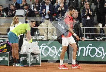 2022-05-31 - Novak Djokovic of Serbia leaves the court after his defeat while Rafael Nadal of Spain (left) looks at him during day 10 of Roland-Garros 2022, French Open 2022, second Grand Slam tennis tournament of the season on May 31, 2022 at Roland-Garros stadium in Paris, France - TENNIS - ROLAND GARROS 2022 - WEEK 2 - INTERNATIONALS - TENNIS