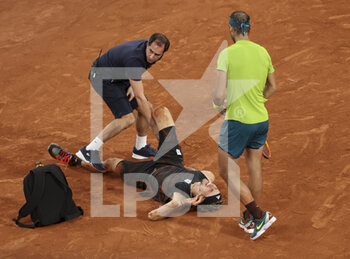 2022-06-03 - Alexander Zverev of Germany lies down with a severe injury on his right ankle while Rafael Nadal of Spain looks on during their semifinal on day 13 of Roland-Garros 2022, French Open 2022, second Grand Slam tennis tournament of the season on June 2, 2022 at Roland-Garros stadium in Paris, France - TENNIS - ROLAND GARROS 2022 - WEEK 2 - INTERNATIONALS - TENNIS