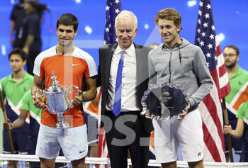 11/09/2022 - Winner Carlos Alcaraz of Spain, trophy presenter John McEnroe, finalist Casper Ruud of Norway during the men's final trophy ceremony on day 14 of the US Open 2022, 4th Grand Slam tennis tournament of the season on September 11, 2022 at USTA National Tennis Center in New York, United States - TENNIS - US OPEN 2022 - WEEK 2 - INTERNAZIONALI - TENNIS