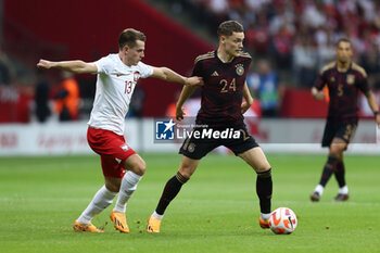 2023-06-16 - Jakub Kaminski of Poland Florian Wirtz of Germany during the International Friendly Football match between Poland and Germany on June 16, 2023 at PGE Narodowy in Warsaw, Poland - FOOTBALL - FRIENDLY GAME - POLAND V GERMANY - FRIENDLY MATCH - SOCCER