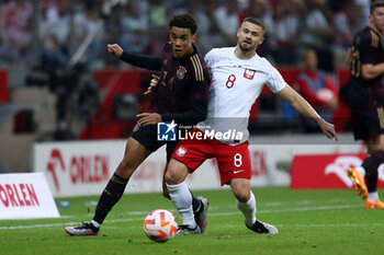 2023-06-16 - Jamal Musiala of Germany Karol Linetty of Poland during the International Friendly Football match between Poland and Germany on June 16, 2023 at PGE Narodowy in Warsaw, Poland - FOOTBALL - FRIENDLY GAME - POLAND V GERMANY - FRIENDLY MATCH - SOCCER