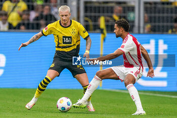 2023-08-06 - Devyne Rensch of Ajax is challenged by Marco Reus of Borussia Dortmund during the Pre-season Friendly football match between Borussia Dortmund and Ajax on August 6, 2023 at Signal Iduna Park in Dortmund, Germany - FOOTBALL - FRIENDLY GAME - DORTMUND V AJAX - FRIENDLY MATCH - SOCCER