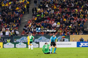 2023-12-11 - Referee Kristoffer Karlsson of Sweeden helping Conor Bradley of Northern Ireland stand up during the International Friendly football match between Romania and Northern Ireland on March 22, 2024 at Arena Nationala in Bucharest, Romania - FOOTBALL - FRIENDLY GAME - ROMANIA V NORTHERN IRELAND - FRIENDLY MATCH - SOCCER