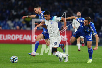 2023-03-23 - Jude Bellingham of England(C) vies for the ball with Jorginho (L) and Rafael Toloi (R) of Italy during the UEFA Euro 2024, European Qualifiers, Group C football match between Italy and England on March 23, 2023 at Stadio Diego Armando Maradona in Naples, Italy - FOOTBALL - EURO 2024 - QUALIFYING - ITALY V ENGLAND - UEFA EUROPEAN - SOCCER