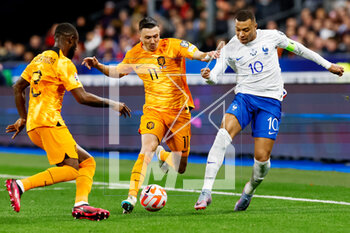 2023-03-24 - Lutsharel Geertruida of the Netherlands and Steven Berghuis of the Netherlands challenge Kylian Mbappe of France during the UEFA Euro 2024, European Qualifiers, Group B football match between France and Netherlands on March 24, 2023 at Stade de France in Saint-Denis near Paris, France - FOOTBALL - EURO 2024 - QUALIFYING - FRANCE V NETHERLANDS - UEFA EUROPEAN - SOCCER