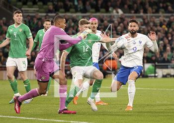 2023-03-27 - Olivier Giroud of France (right), left goalkeeper of Ireland Gavin Bazunu, Nathan Collins of Ireland during the UEFA Euro 2024, European Qualifiers, Group B football match between Republic of Ireland and France on March 27, 2023 at Dublin Arena in Dublin, Republic of Ireland - FOOTBALL - EURO 2024 - QUALIFYING - REPUBLIC OF IRELAND V FRANCE - UEFA EUROPEAN - SOCCER